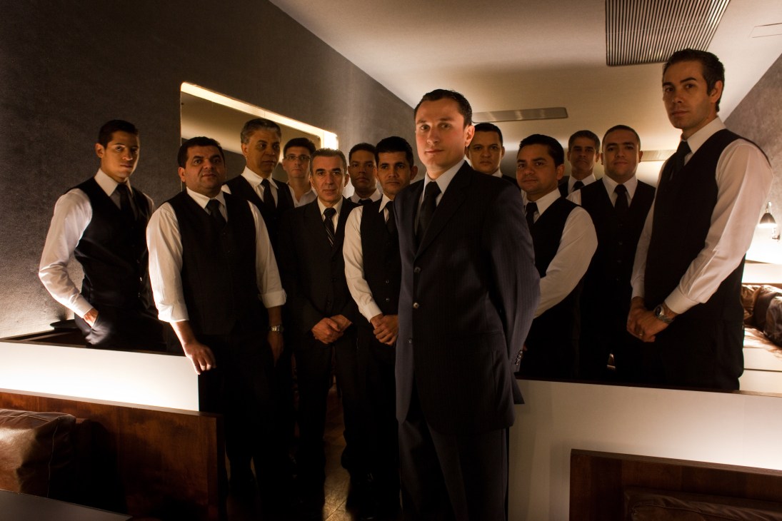 Numero nightclub floor staff in formal black vests and white shirts standing together at the bar