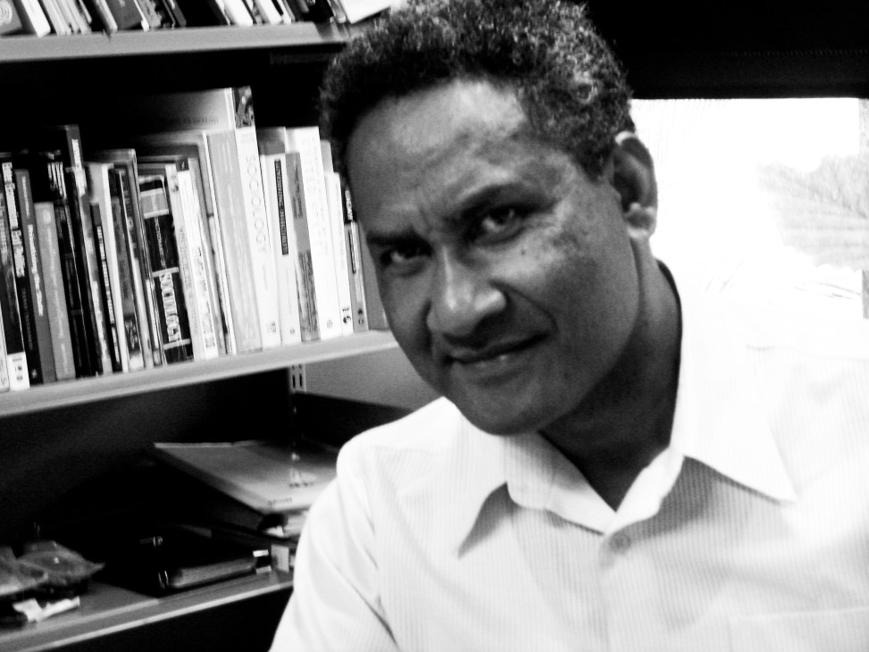 Dr. Steven Ratuva, a senior lecturer at the University of Auckland's Centre for Pacific Studies, in his office with bookshelves behind him.