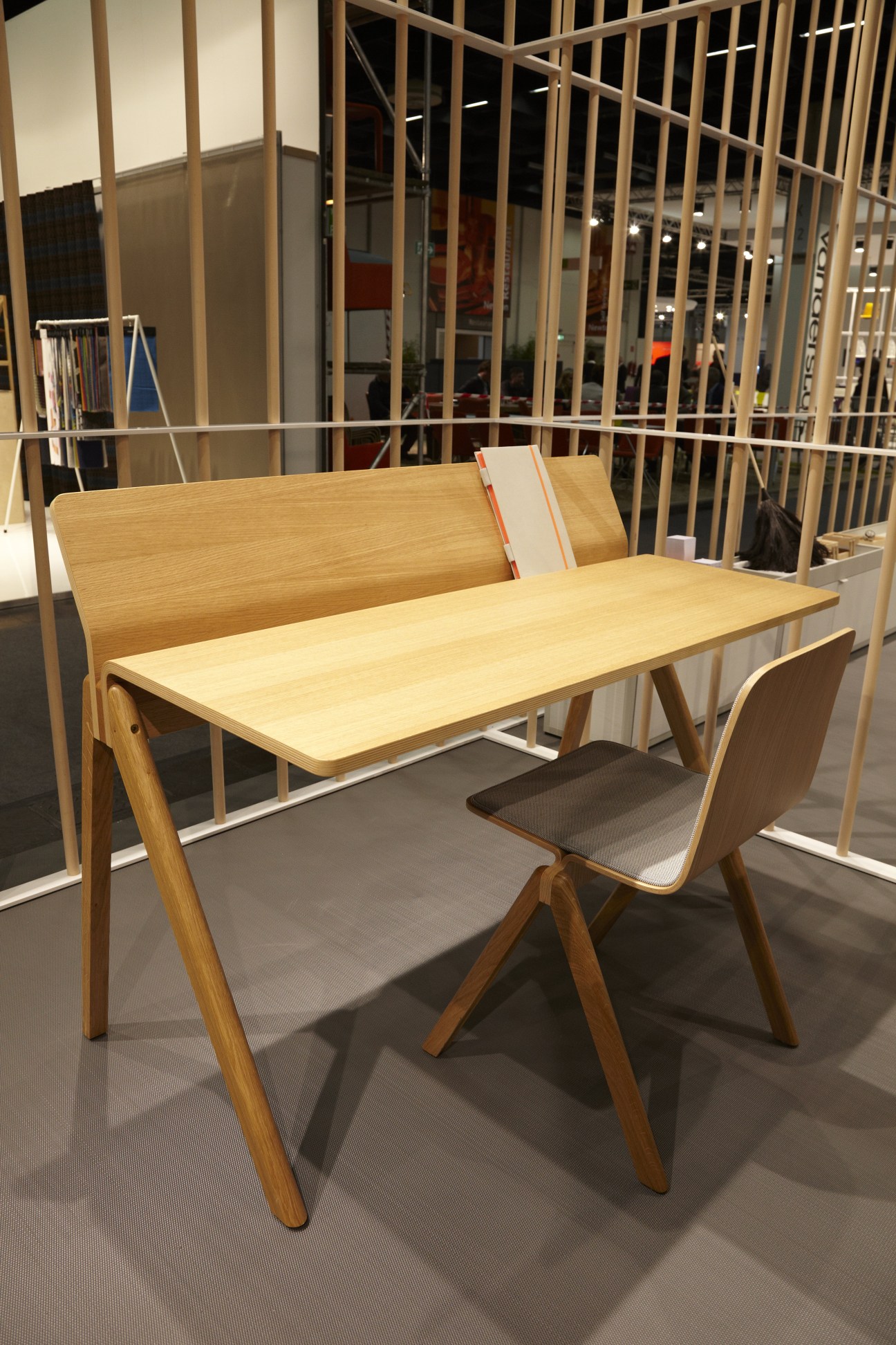 Bouroullec Desk by Hay, a light wood desk with matching chair on display at a trade show booth.