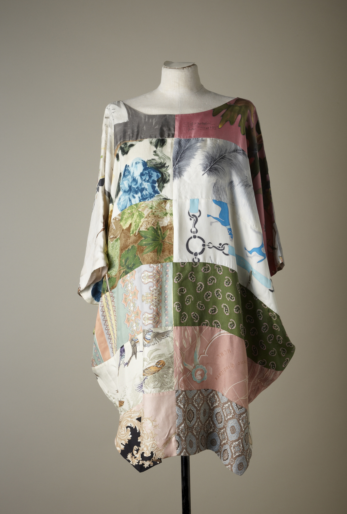 Patchwork tunic dress with mixed textile patterns displayed on a dress form.