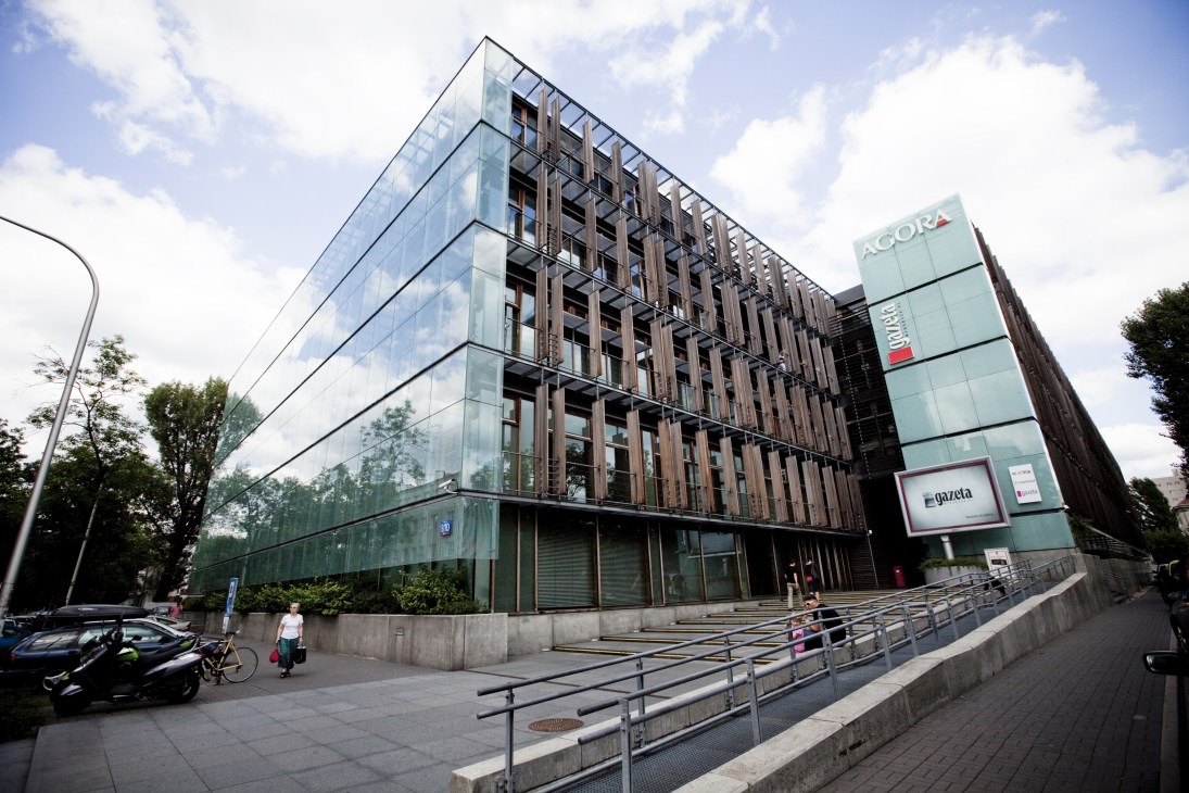 Modern glass and brick office building with Gazeta Wyborcza and Acora signage on facade.