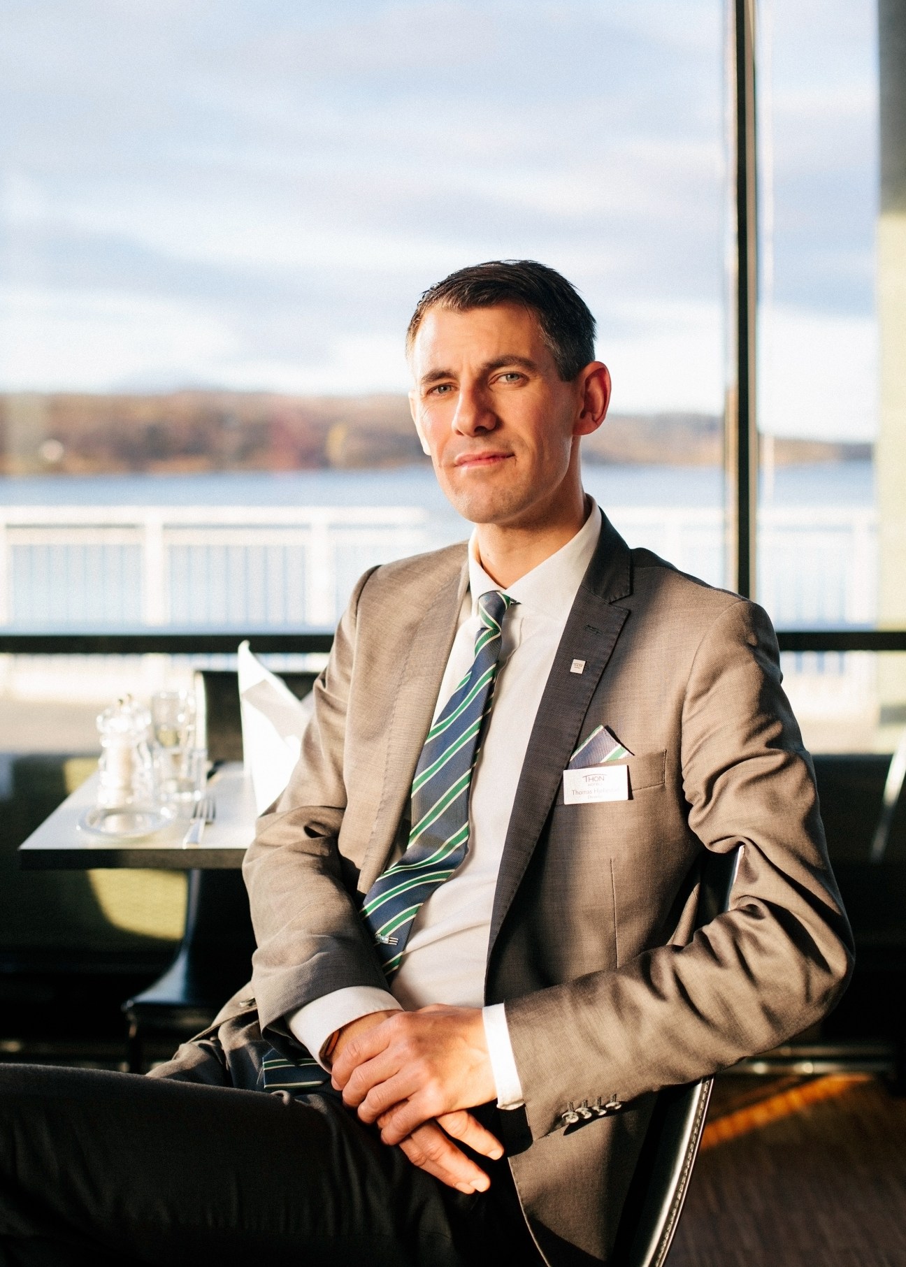 Thomas Hjellestad, manager of Thon Hotel Kirkenes, stands by a window overlooking a fjord.