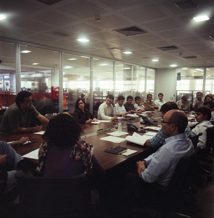 Journalists and editors gathered around a conference table during a daily editorial meeting at Folha de S.Paulo newspaper.