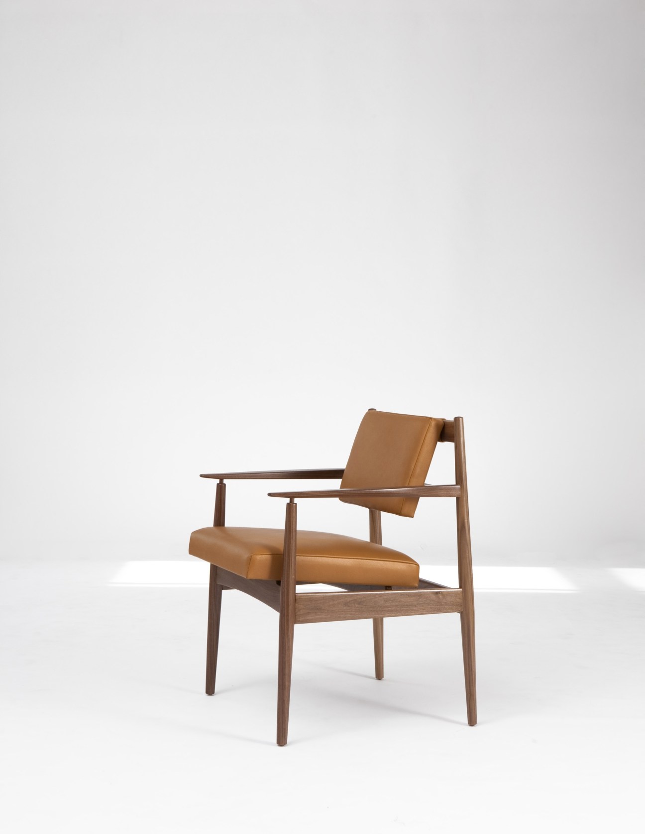 Mid-century modern armchair with walnut wood frame and cognac leather upholstery by Jens Risom.