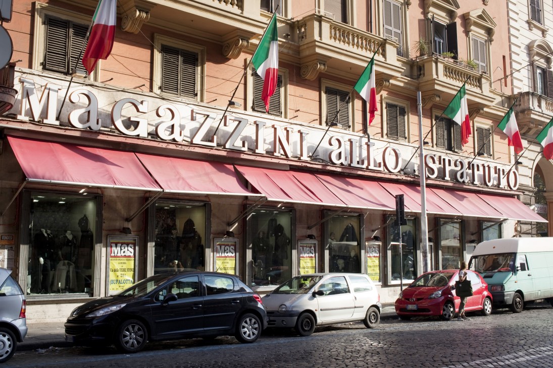 Magazzini allo Statuto department store facade with pink awning and Italian flags on Esquilino street.