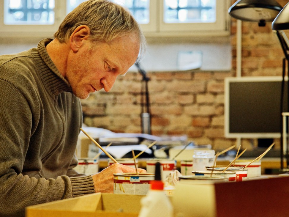 Model-making technician Jörg Albeke works on architectural models at his desk.