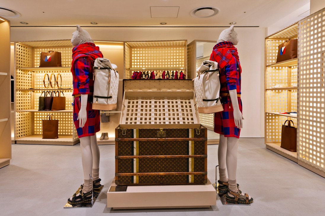 Louis Vuitton display at Dover Street Market Ginza with mannequins wearing red plaid outfits and leather goods on latticed shelving.