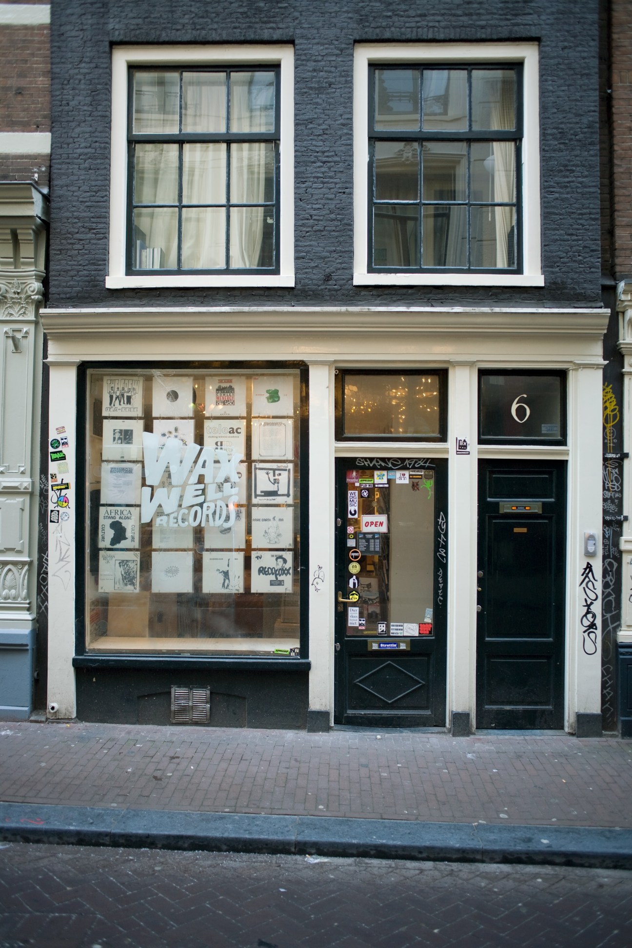 Storefront of Waxwell Records in Amsterdam with large window displaying vinyl records and posters.