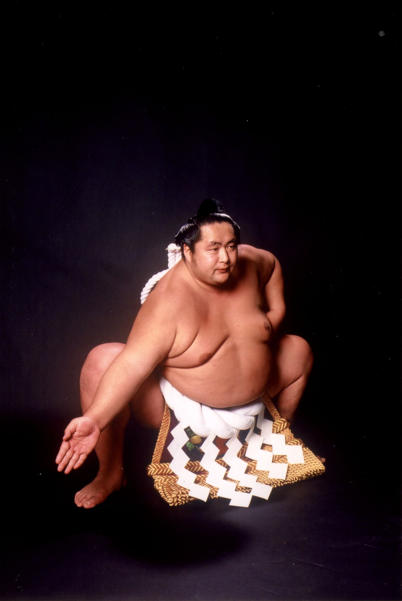 Master Shibatayama in traditional sumo wrestler pose during his competitive career, shirtless wearing ornate belt.