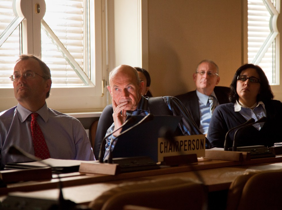 WTO Director General Pascal Lamy sits at a conference table with staff during a meeting.