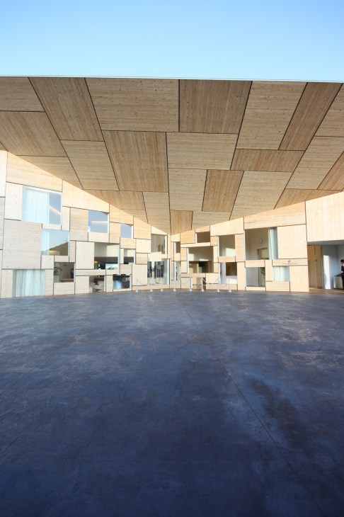 Interior of Garden Terrace hotel showing angular light wood ceiling panels and mirrored walls in Nagasaki.