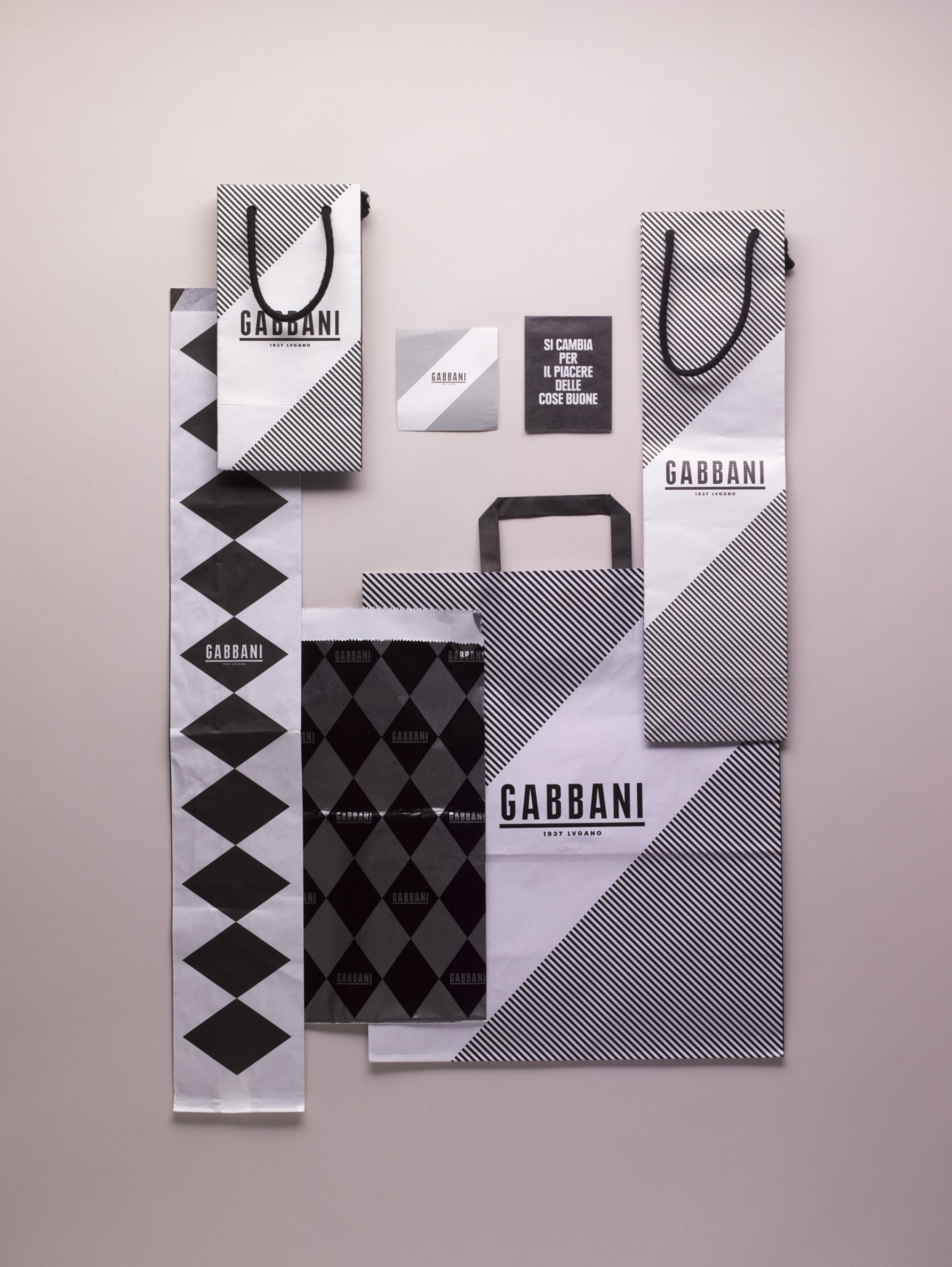 Gabbani deli branding featuring black-and-white striped shopping bags and logo in 1920s font designed by Demian Conrad.