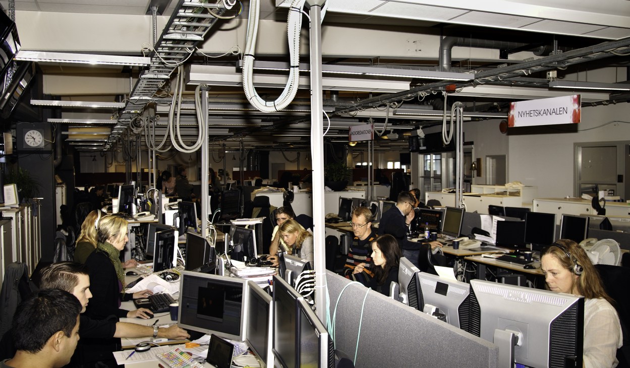 TV4 newsroom with multiple employees working at desks with computers and equipment.