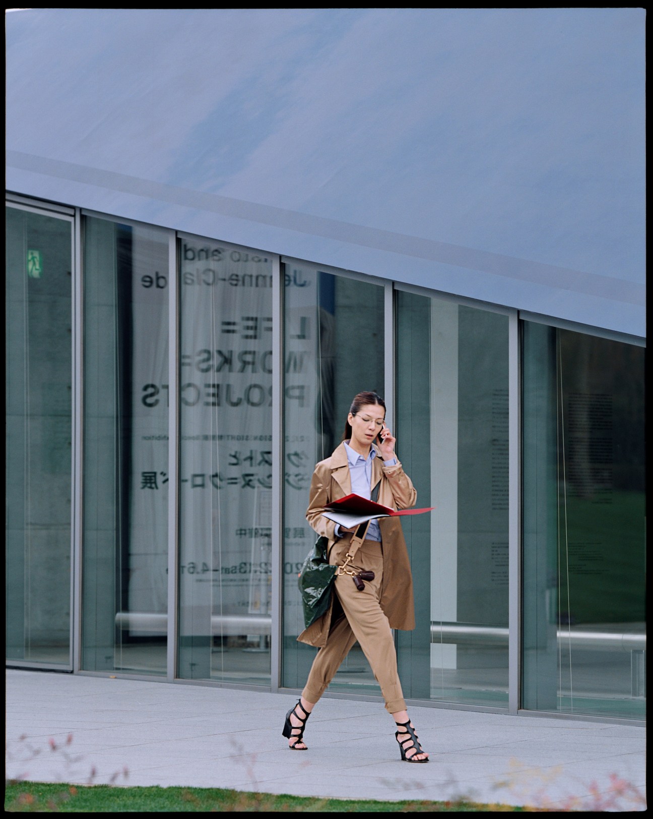 Model wearing Ralph Lauren Black Label coat and trousers with Comme des Garçons shirt outside 21_21 Design Sight in Tokyo.