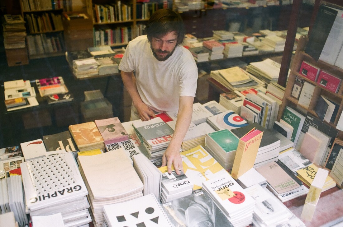Man browsing magazines and publications at Motto bookstore in Berlin's Kreuzberg district.