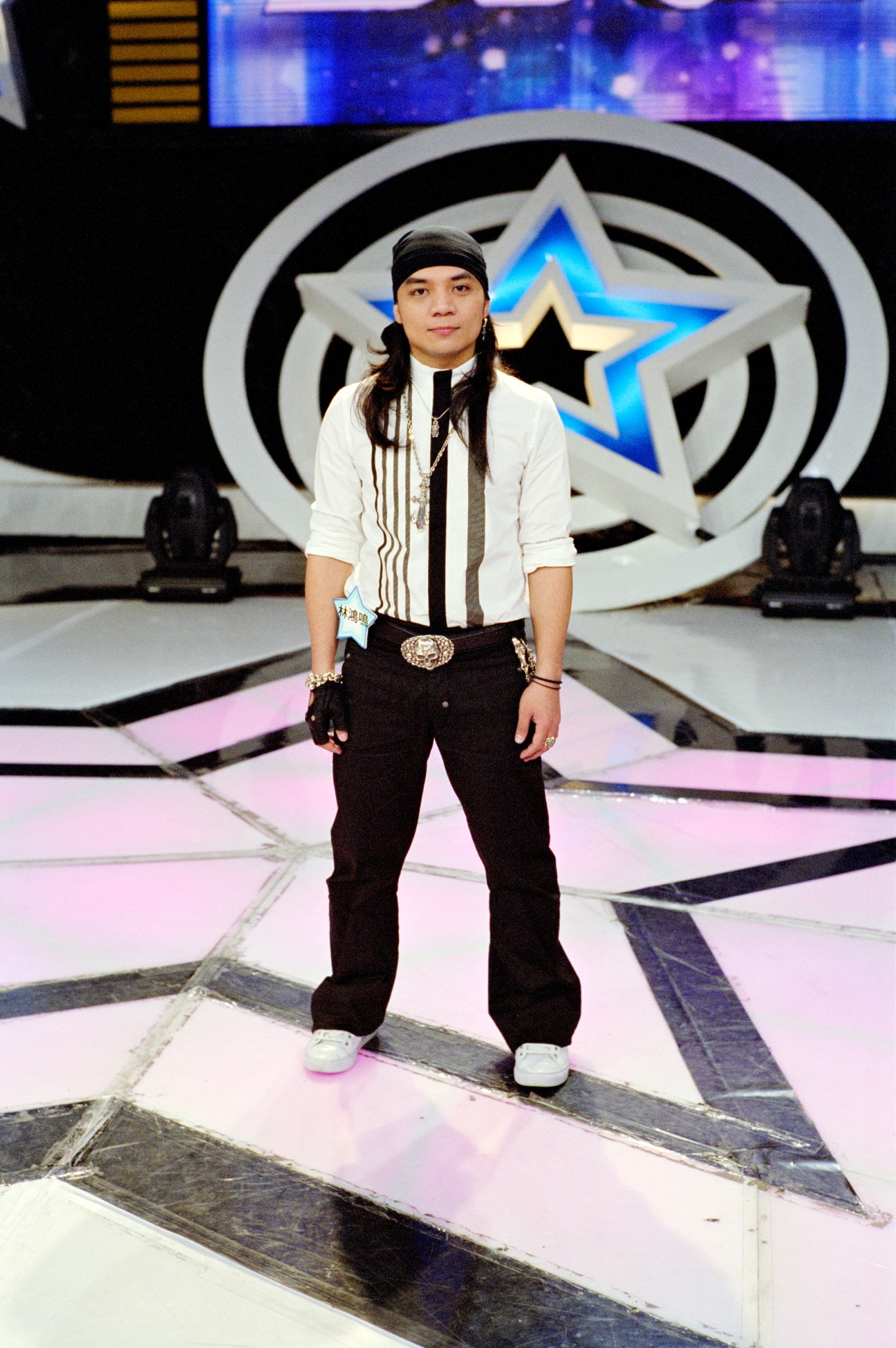 Young contestant on stage at One Million Star talent show with star-shaped set backdrop.