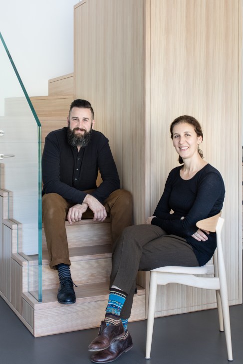 Walter Carminati and Sandra Andreis sitting together in a modern interior with wooden paneling.