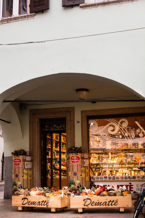 Demattè fruit shop storefront with wooden boxes of fresh produce displayed outside on the street.