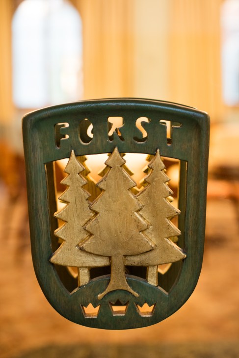 Forst brewery emblem with green shield, pine trees and crown details