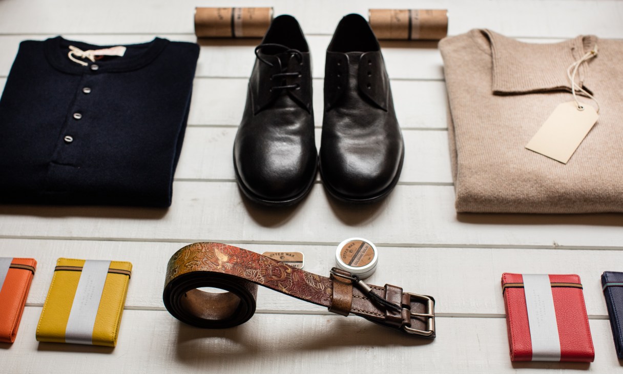 Clothing and accessories displayed at Raccolta Differenziata boutique including sweaters, shoes, belts and wallets.