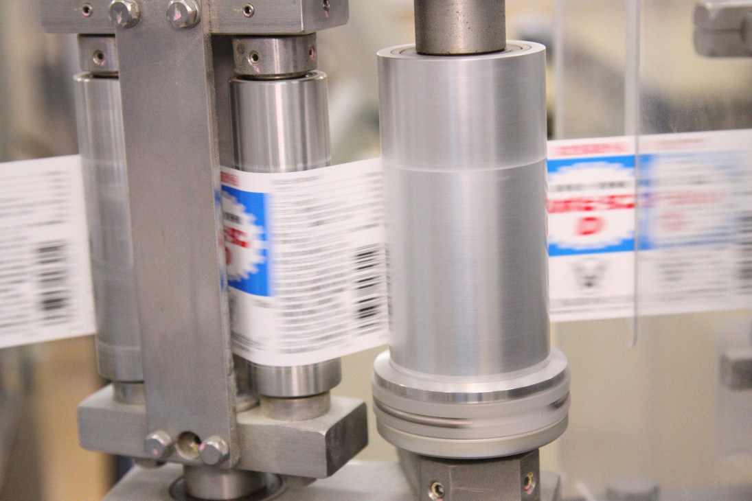 Lipovitan D bottles being labeled with red and blue branded labels on industrial labeling machinery.