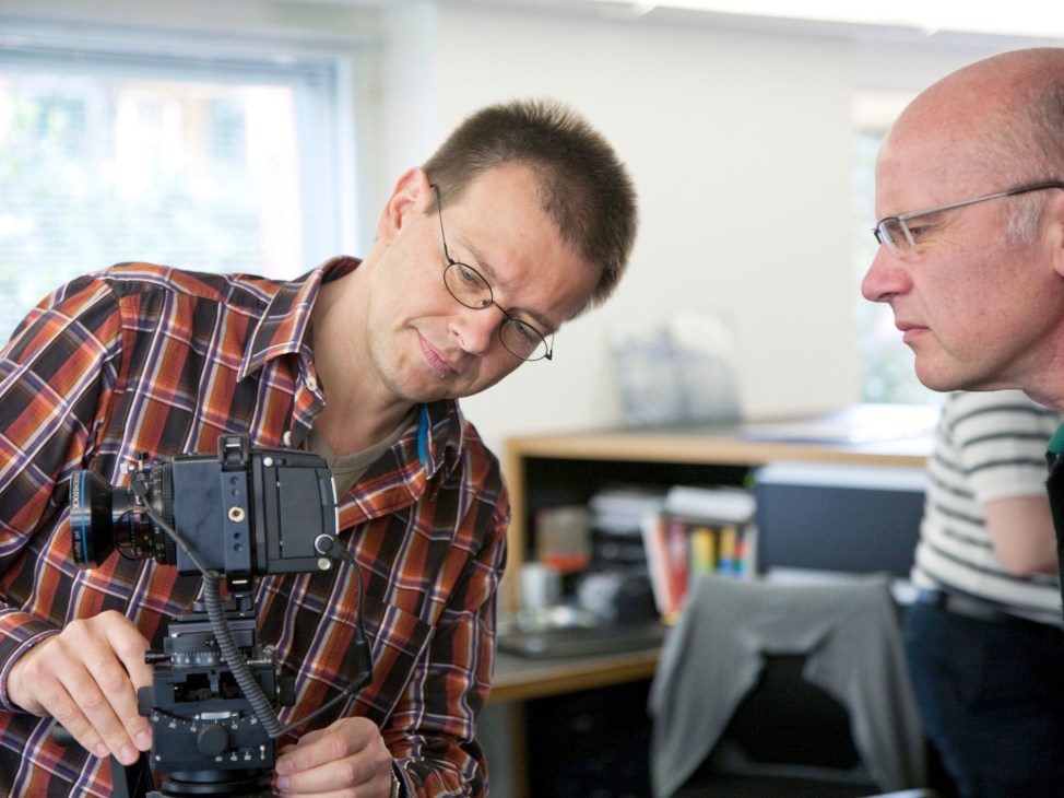 Technical adviser Matthias Wagner demonstrates an Alpa camera to a colleague in the workshop.