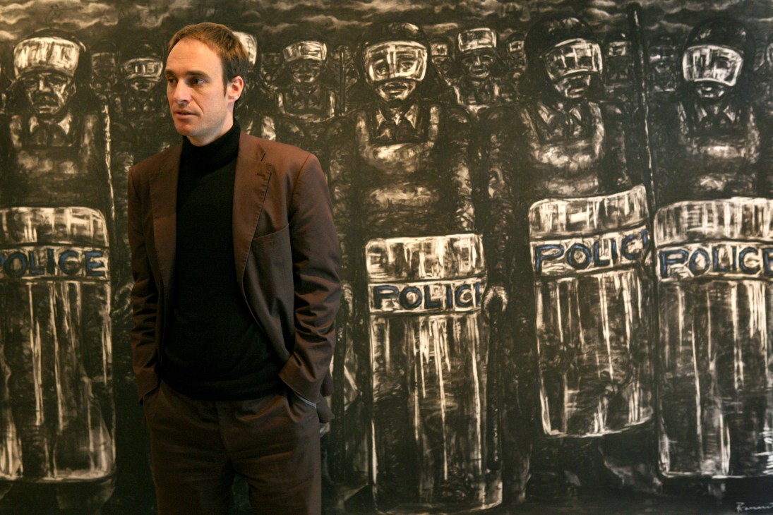 Johannes Hossfeld, director of the Goethe Institut in Nairobi, stands before a wall of embossed metal police riot shields.
