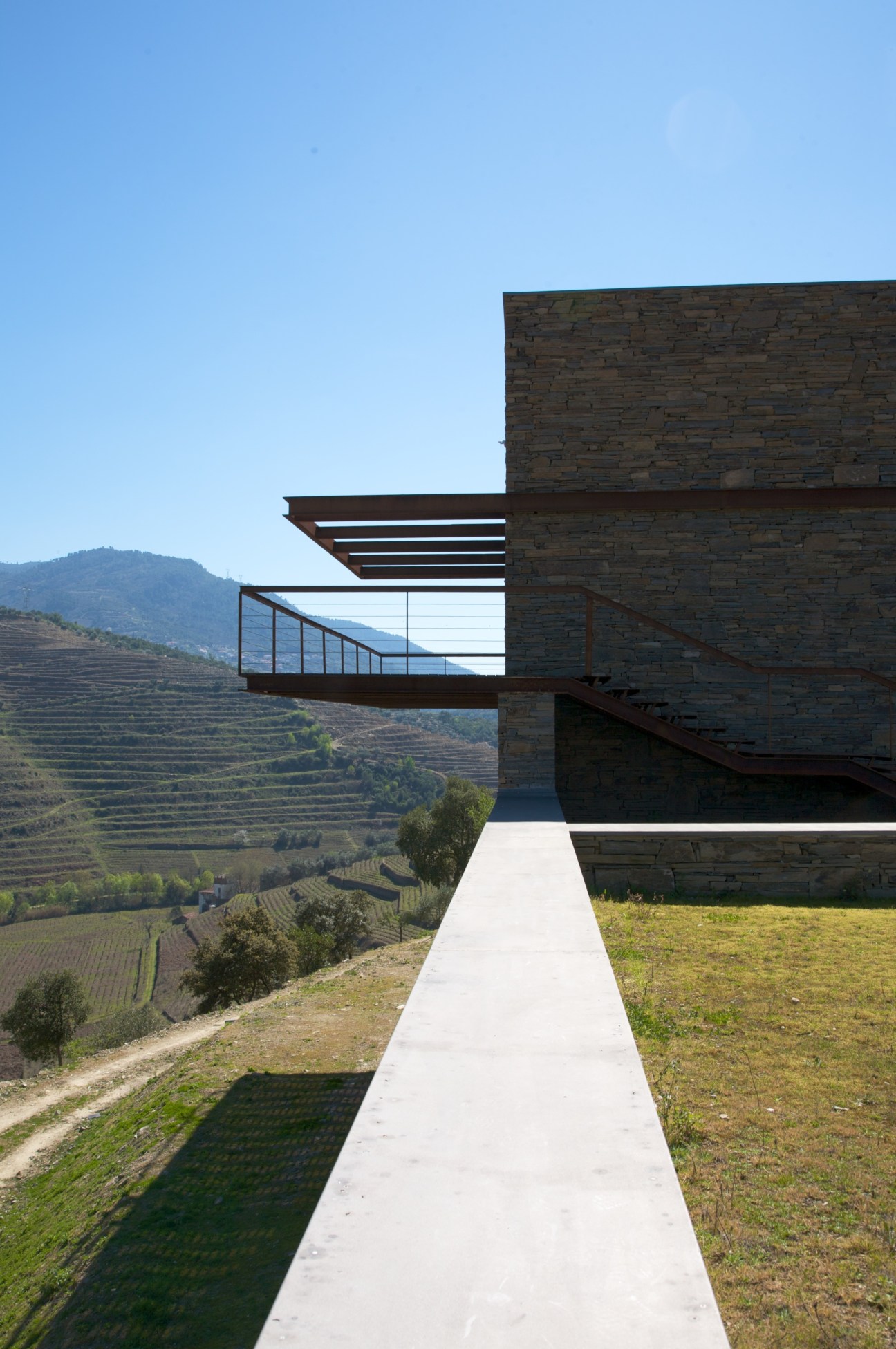 Quinta de Nápoles winery with cantilevered steel terrace overlooking terraced vineyards in Portugal's Douro Valley.