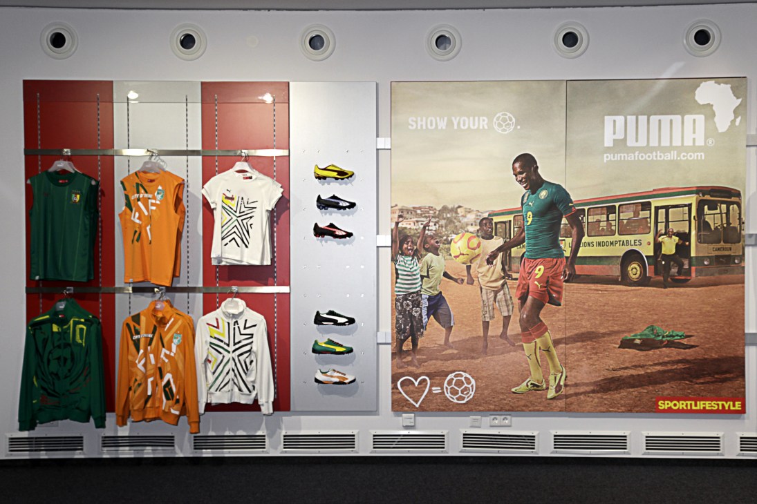 Puma store display window featuring an advertisement with Samuel Eto'o playing football in Cameroon kit with African map logo and Puma branding.