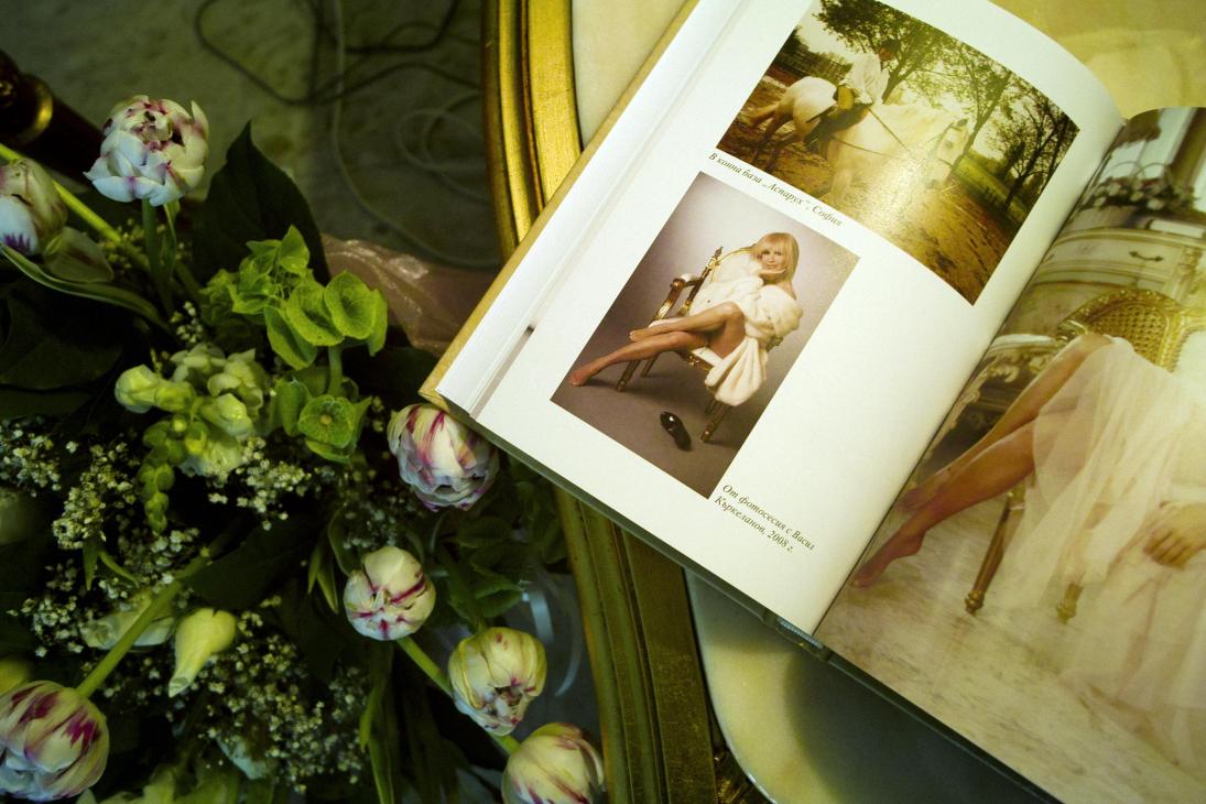Open autobiography book showing portrait of Lili Ivanova beside fresh flowers on a table.