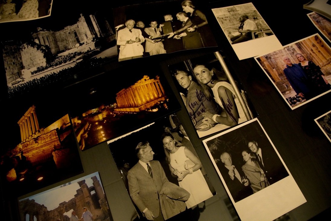 Collection of vintage photographs and images spread on a dark surface, including festival scenes, portraits, and architectural shots from May Arida's album.