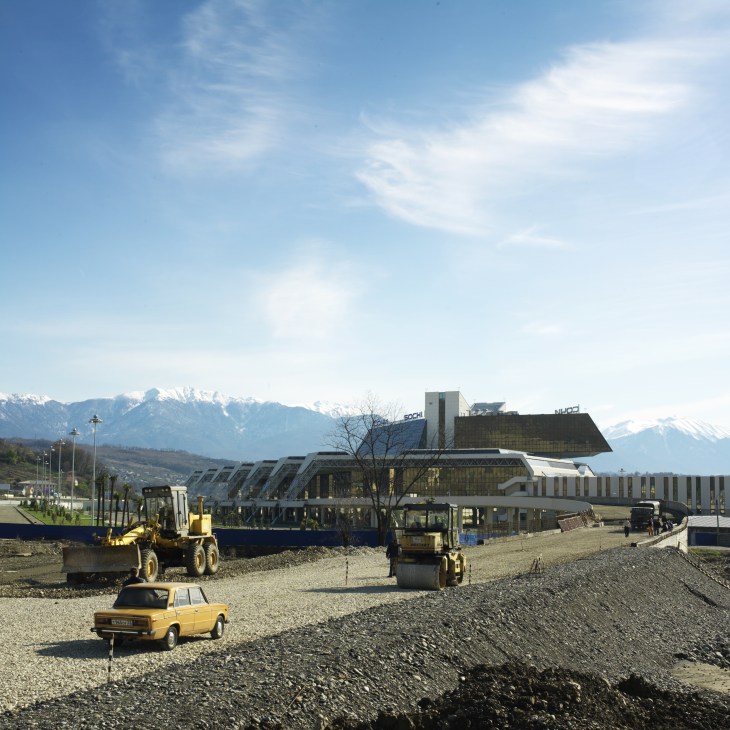 Construction site of Sochi's new airport terminal with Caucasus mountains snow-capped in the background.