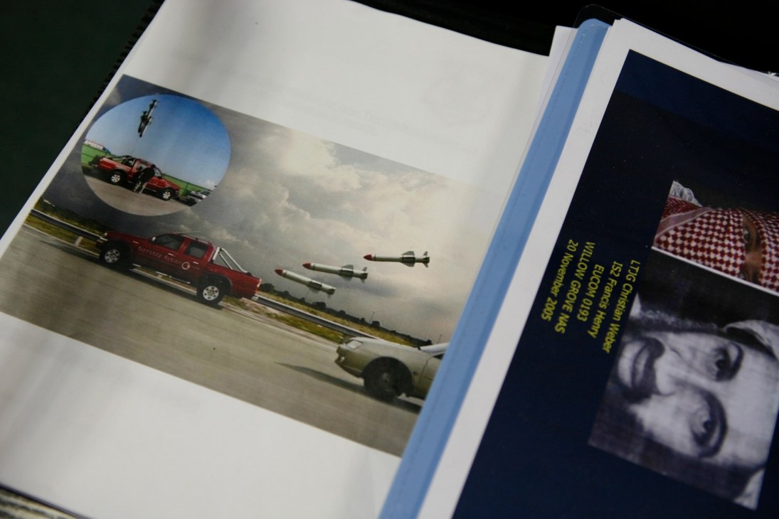 Marked-up photographs at the Aviation Security Unit showing aircraft and threat analysis materials.
