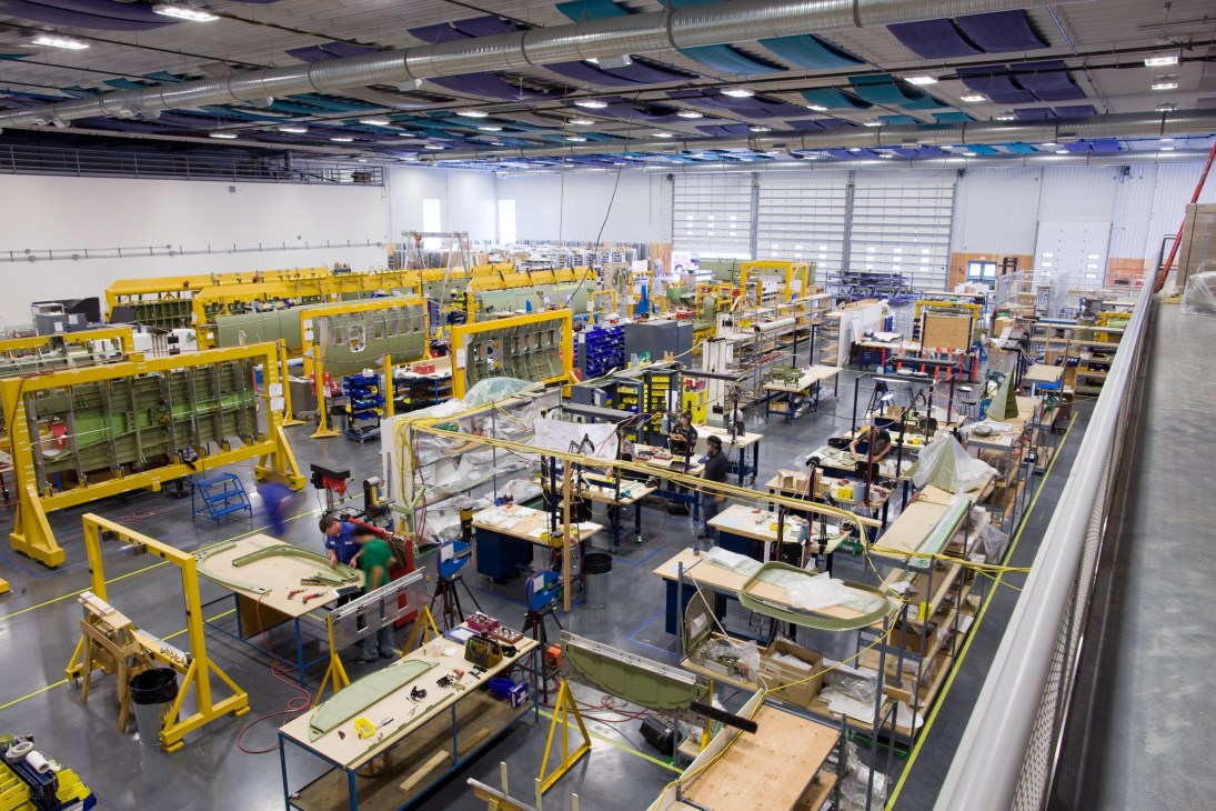 Overhead view of Viking Air's aircraft assembly facility with yellow work stations and Twin Otter fuselages in various stages of production.