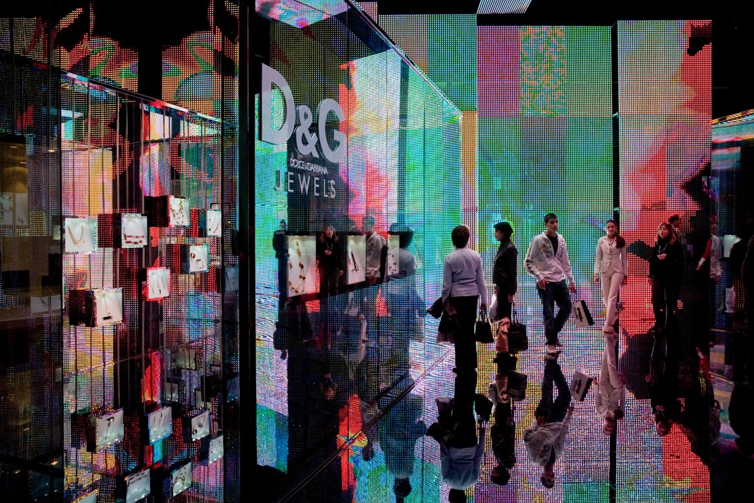 Visitors browse the D&G booth with colorful LED video screens displaying jewelry at Baselworld.