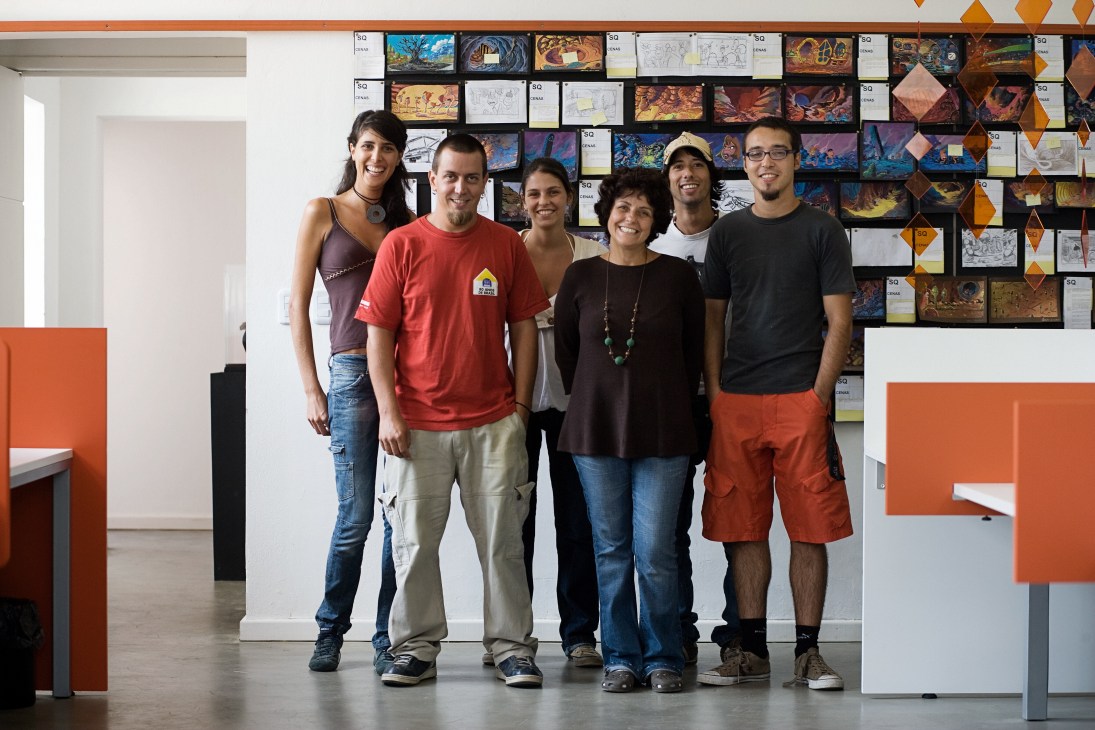 Team of six people standing in an animation studio with storyboards on the wall behind them.