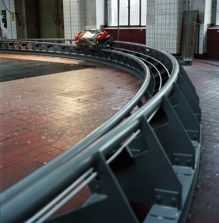 CargoCap test model with red and black coloring on an oval track inside an industrial facility.
