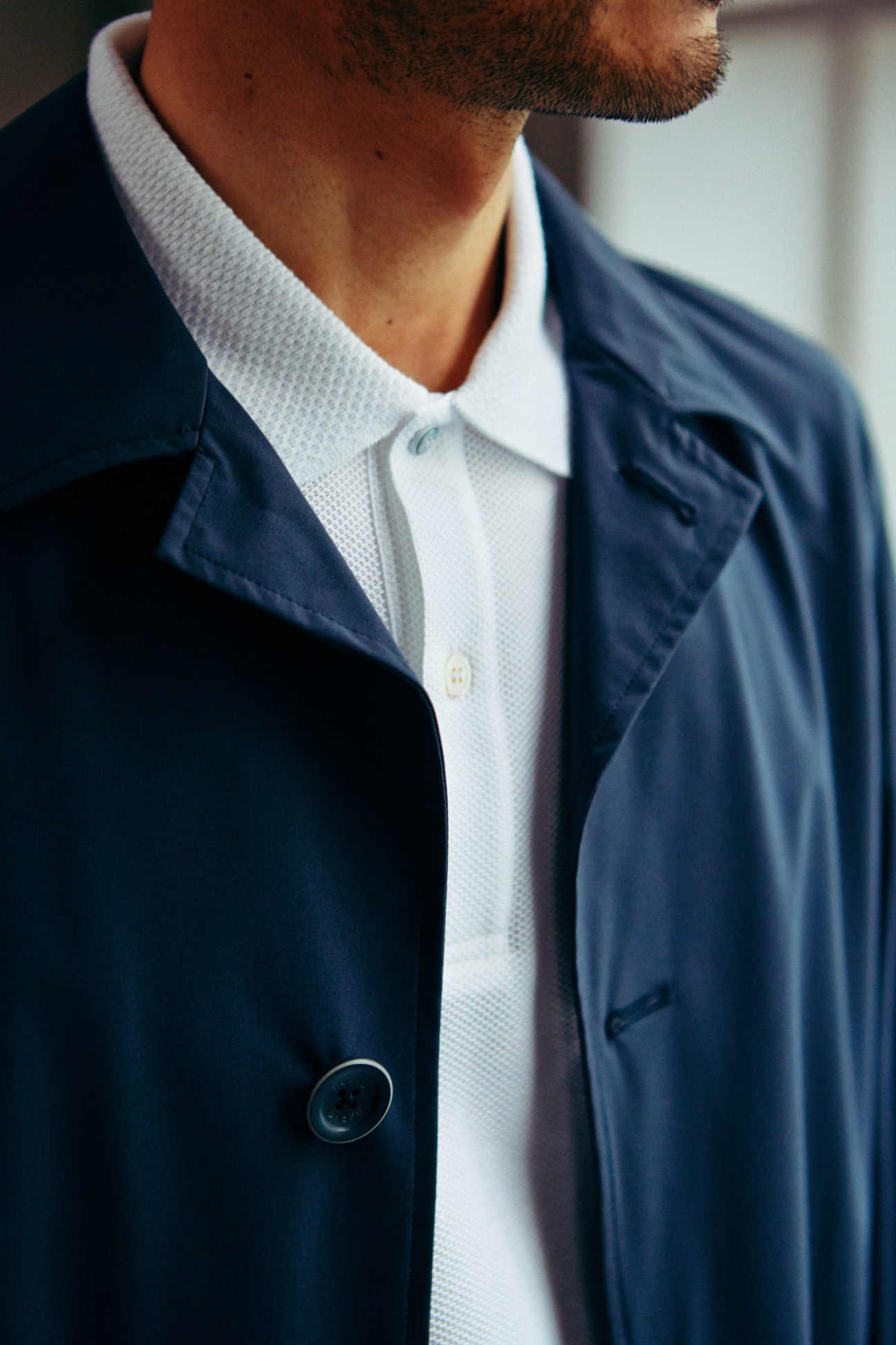 Man wearing navy Herno coat over white Brooksfield poloshirt.