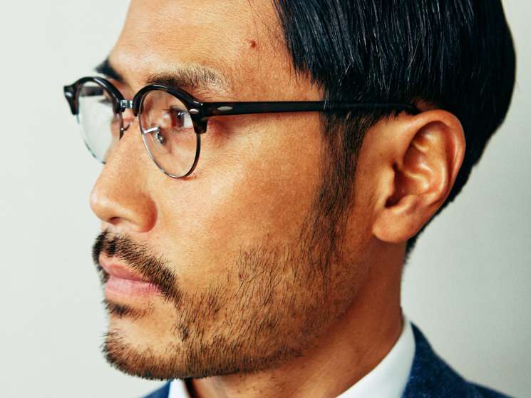 Man in profile wearing Lardini jacket, Colmar jumper, 100Hands shirt, Ray-Ban glasses and Franco Bassi tie.
