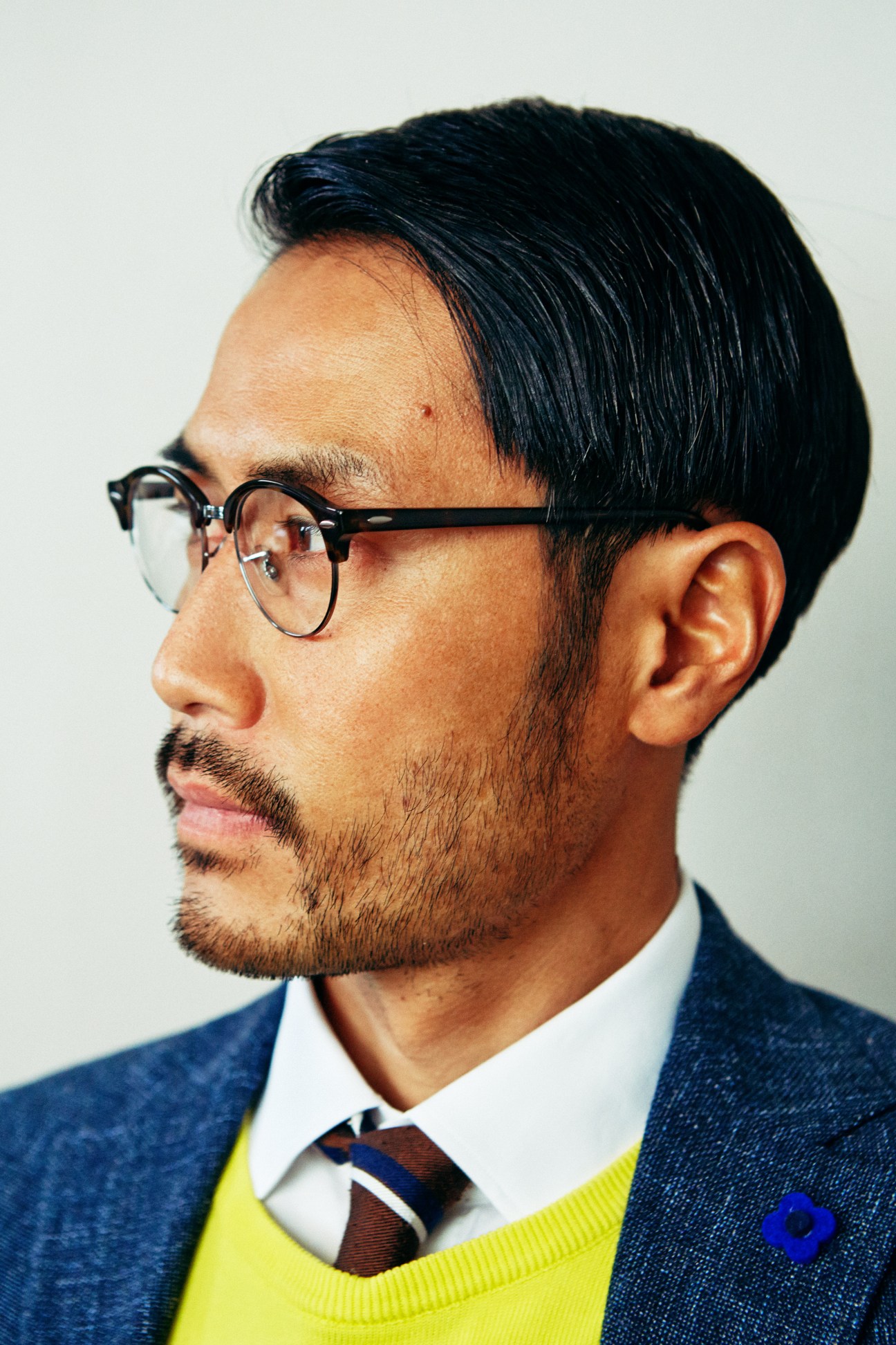 Man in profile wearing Lardini jacket, Colmar jumper, 100Hands shirt, Ray-Ban glasses and Franco Bassi tie.