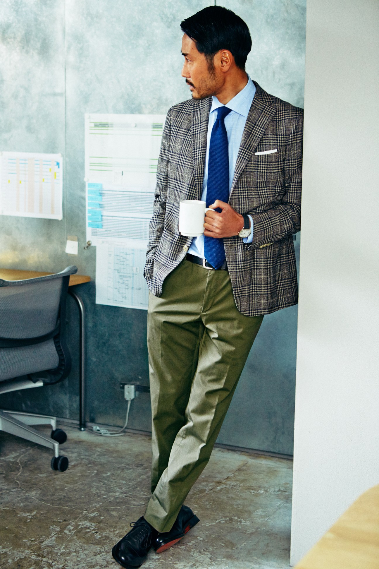 Man in office holding coffee cup wearing Boglioli jacket, Orazio Luciano shirt, and GTA trousers