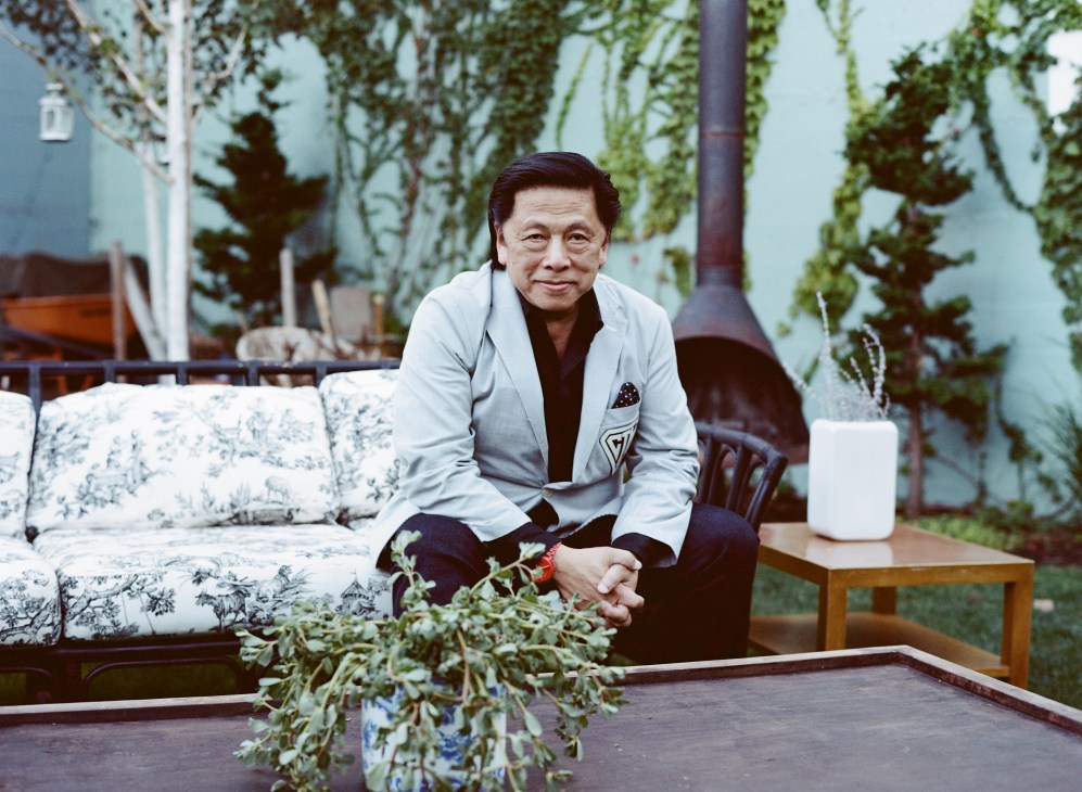 John Jay sits on a patterned sofa in a lush garden setting at Stray Dogs pop-up restaurant.