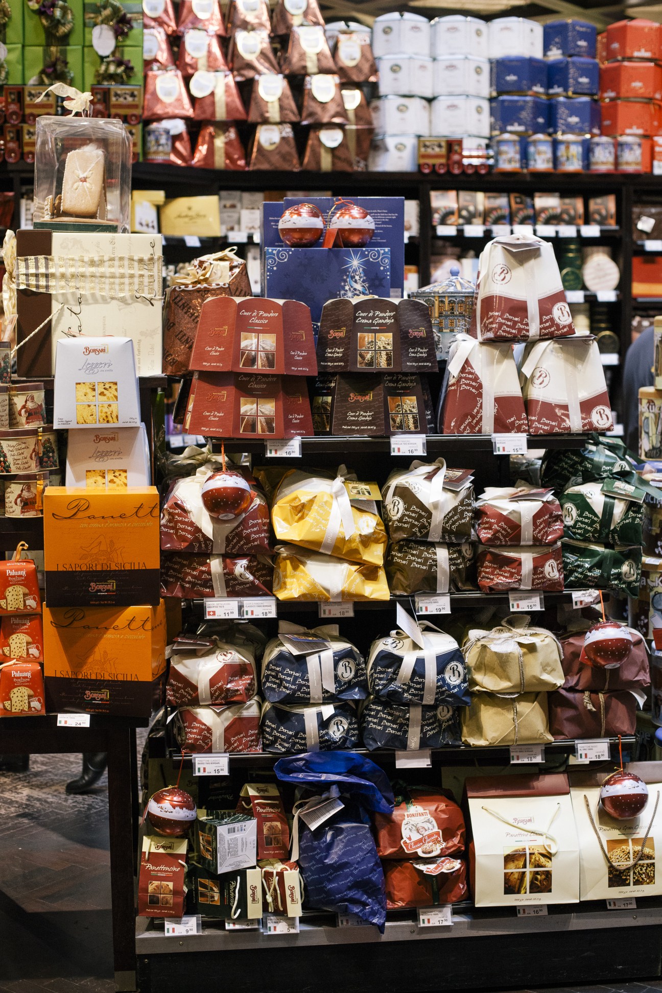Window display of Julius Meinl gourmet store showing packaged chocolates, confectionery, and specialty food products with colorful ribbons and branding.