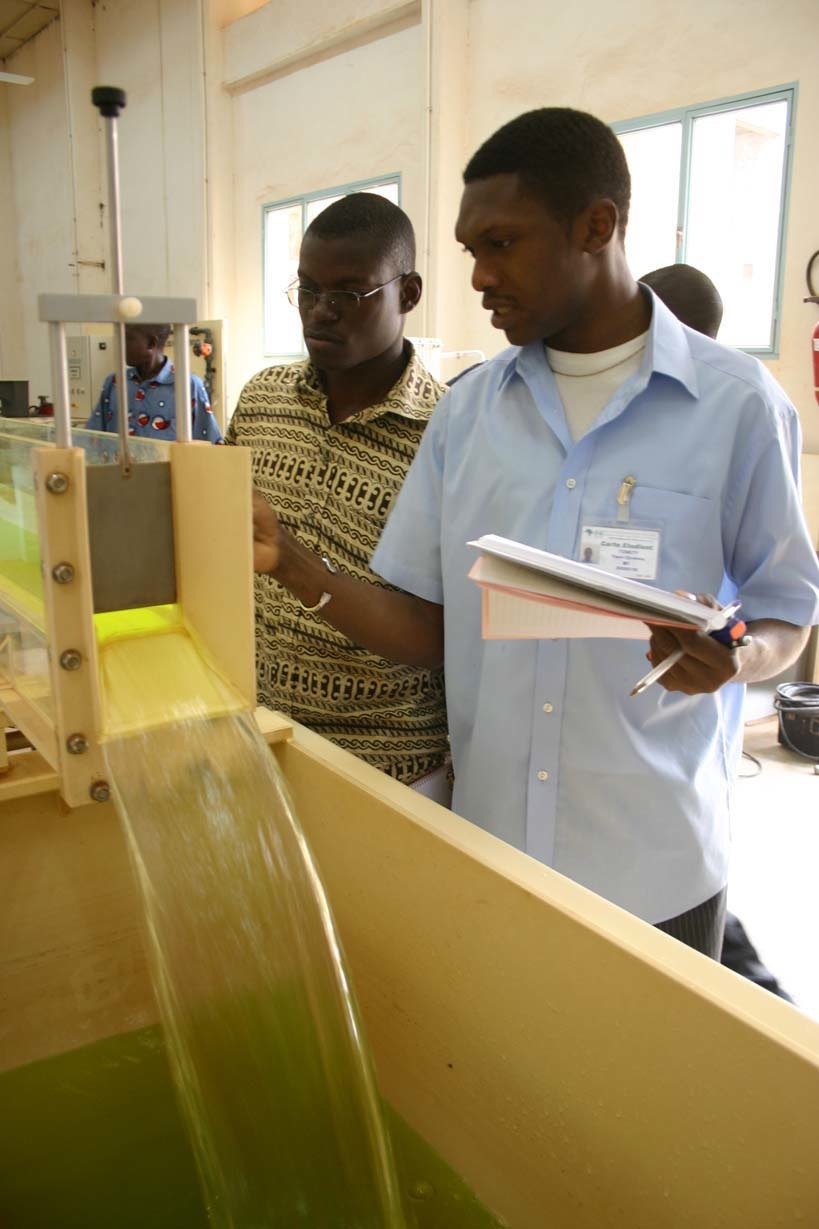 Two men examine water engineering equipment at 2iE institute in Burkina Faso.