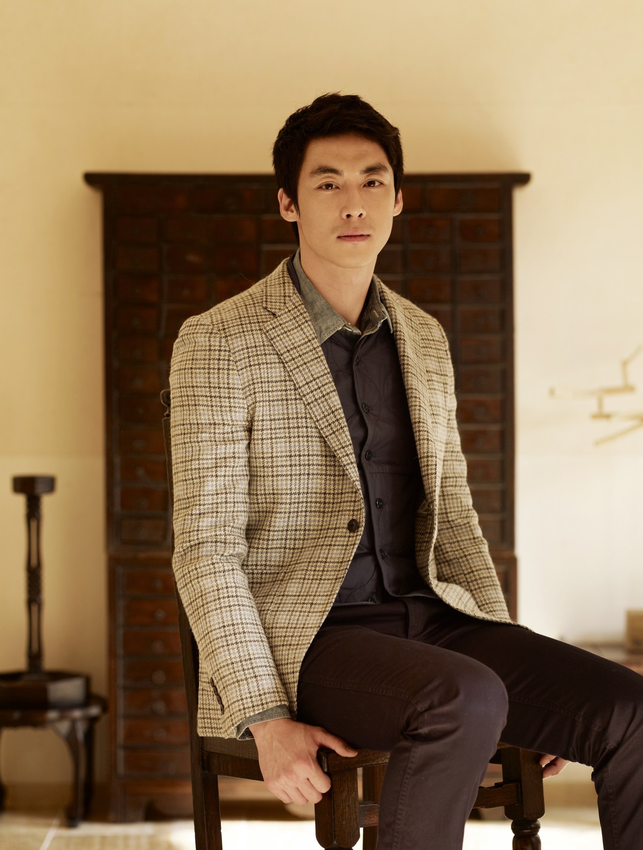 Man seated wearing a patterned beige Kitsuné jacket, dark waistcoat, and J.Crew shirt.