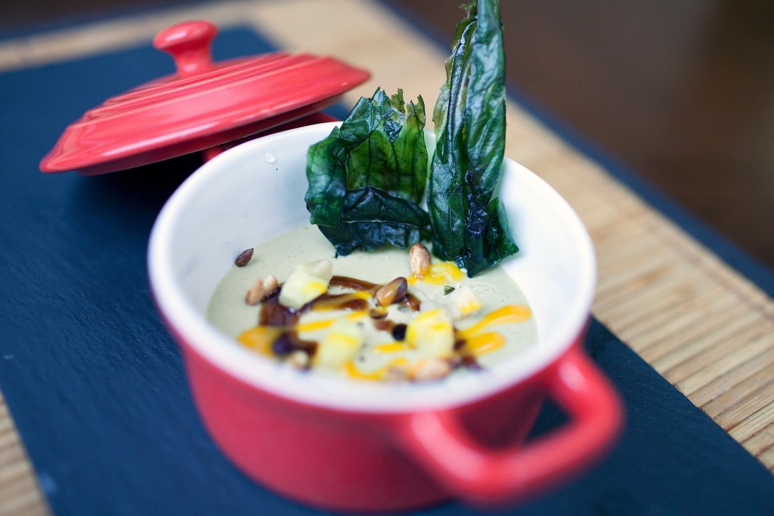 Foie gras with mango and ginger at Hidalgo 56, served in a red dish with dark leafy garnish.