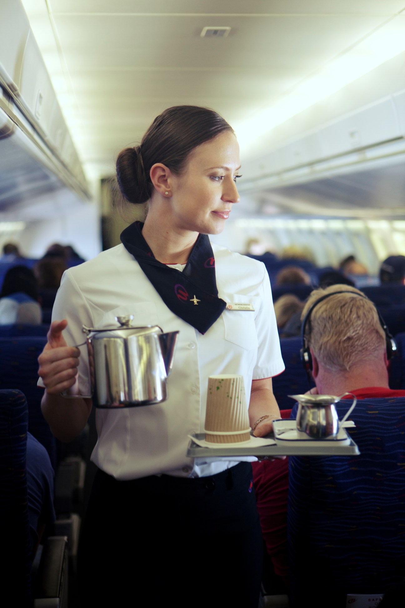 Flight hostess serves coffee to passengers aboard a FIFO flight to mining camps.