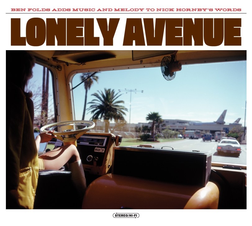 Album cover for Ben Folds & Nick Hornby's Lonely Avenue showing interior of vintage bus with steering wheel and palm trees visible through windows.