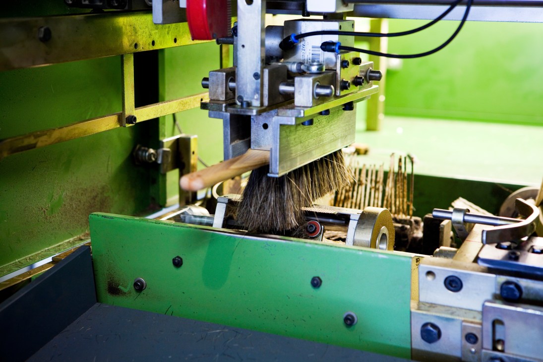 A brush clipping machine trims bristles on an Iris Hantverk brush at the Stockholm workshop.