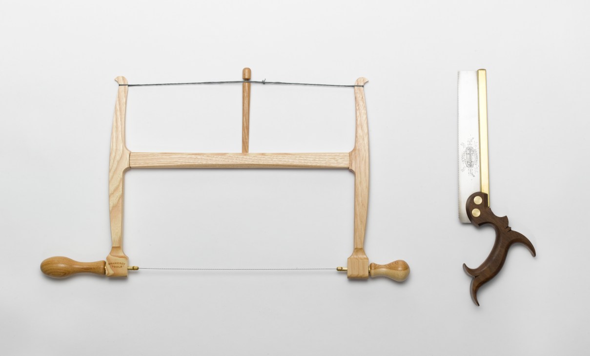 Hand tools from Tools for Working Wood including a bow saw with wooden handles and a dovetail saw with dark walnut handle.